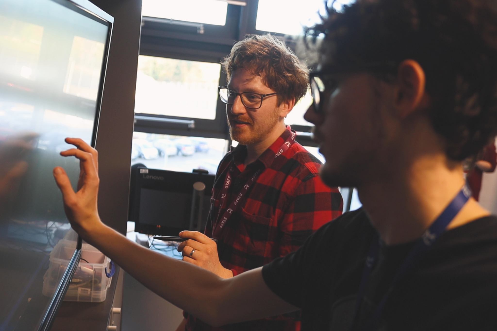 A Creative Media student and Creative Media teacher is looking at a computer screen.