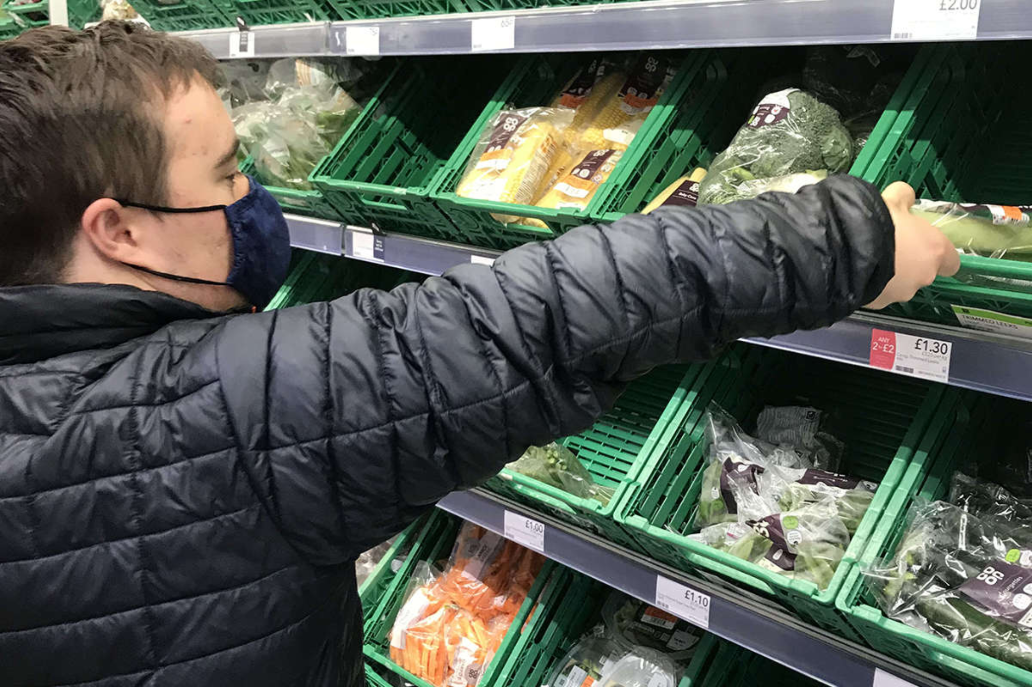 A Pathways student doing food shopping in a supermarket