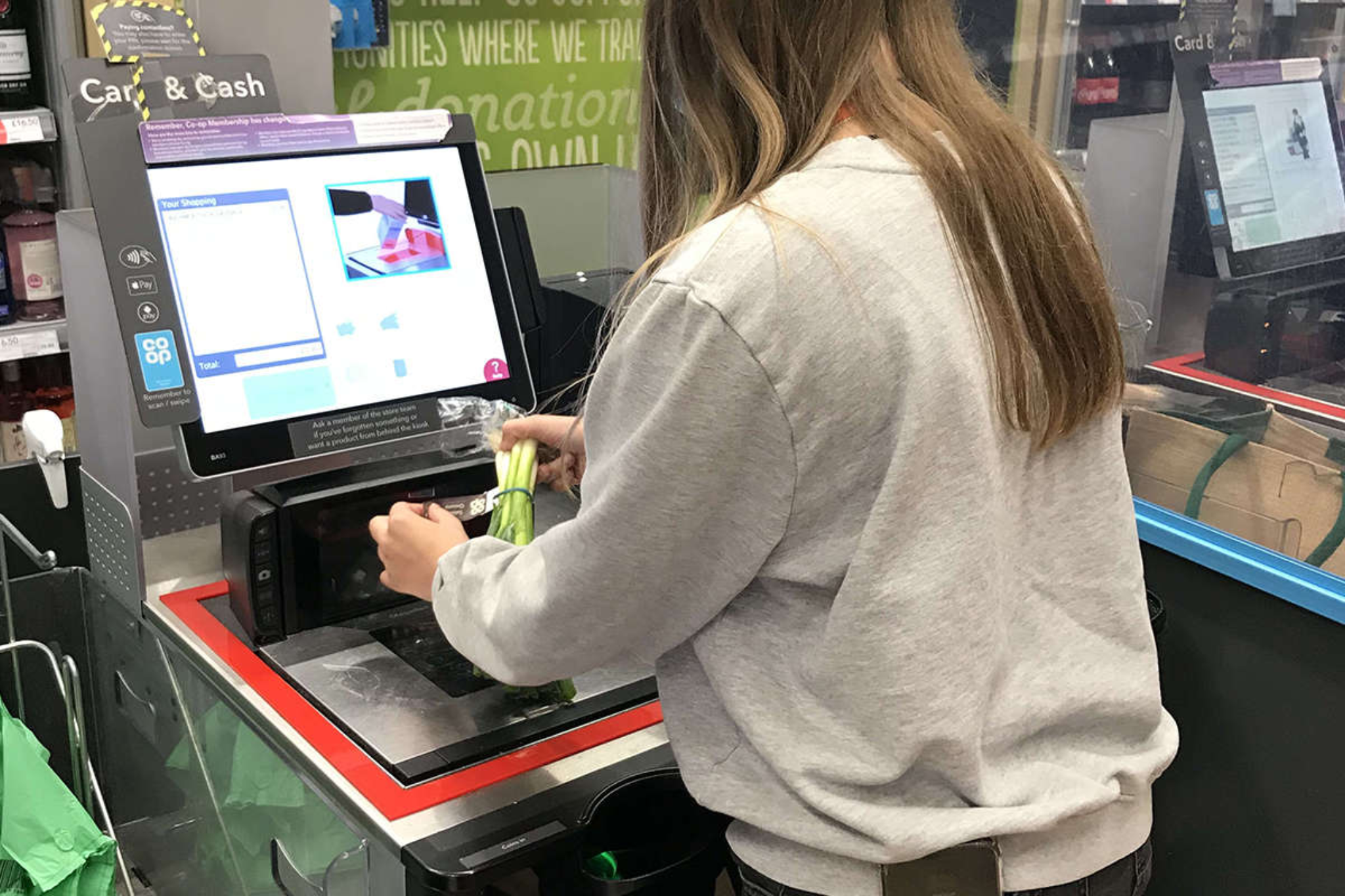 A Pathways student using a self service checkout at a supermarket