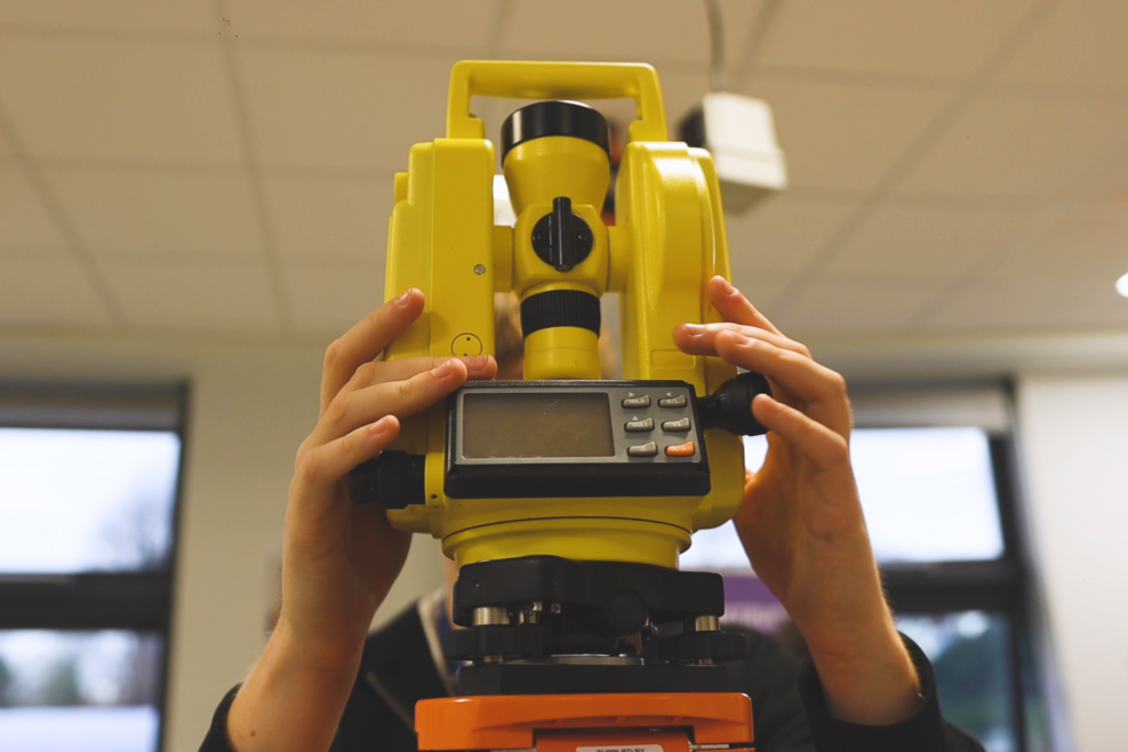 A student is using surveying equipment