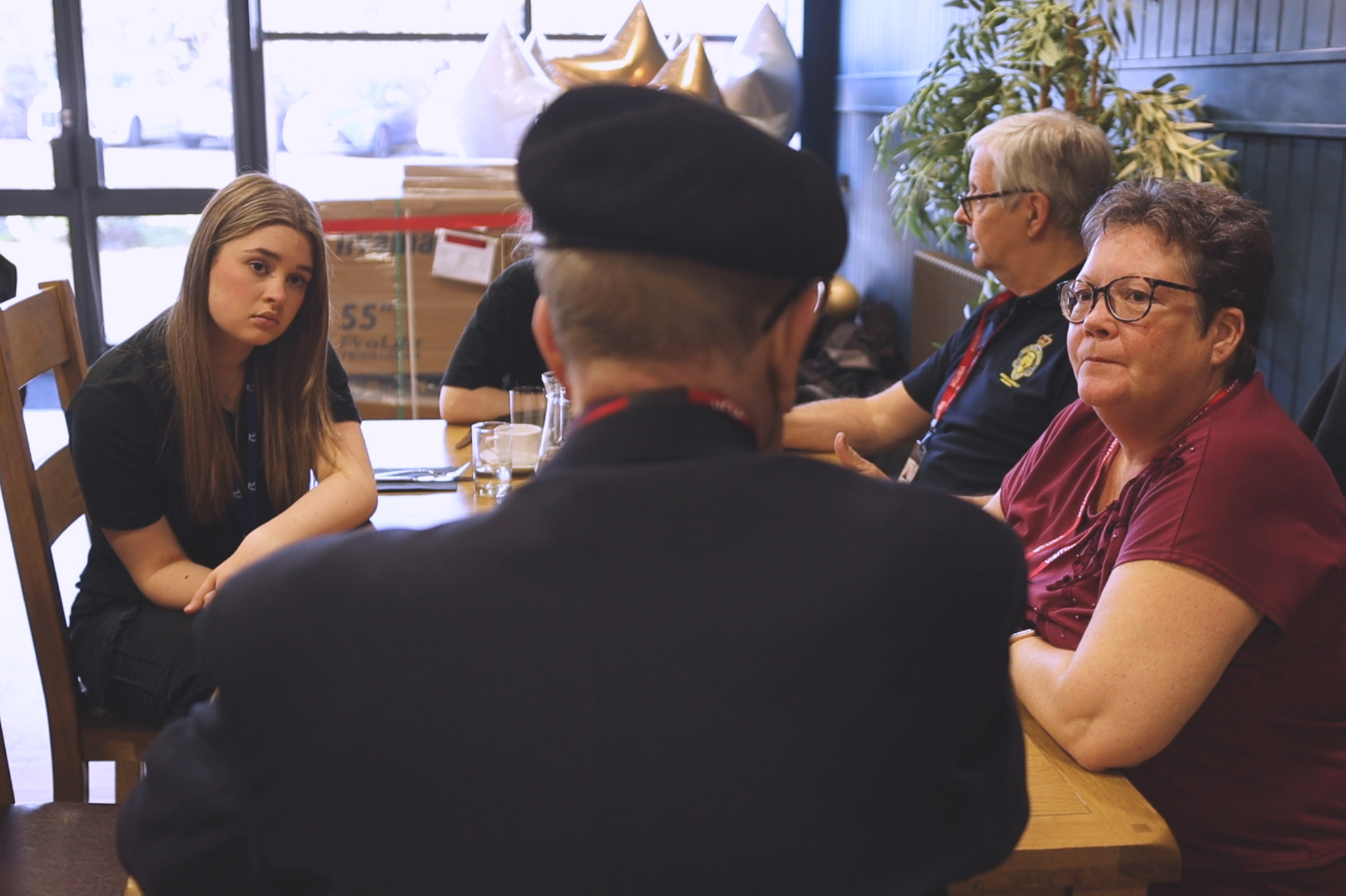 A group of Public Service students are sitting at a table with Army veterans.