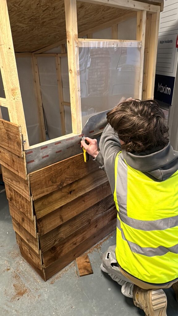 A carpentry and joinery apprentice is building a wendy house