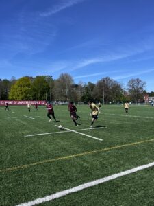 a group of students wearing football kits are playing football