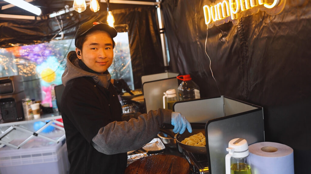 someone is smiling whilst making dumplings