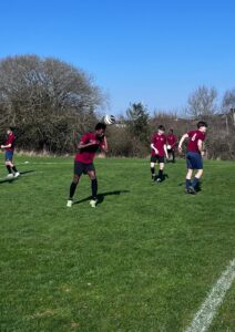 a group of students wearing football kits are playing on football