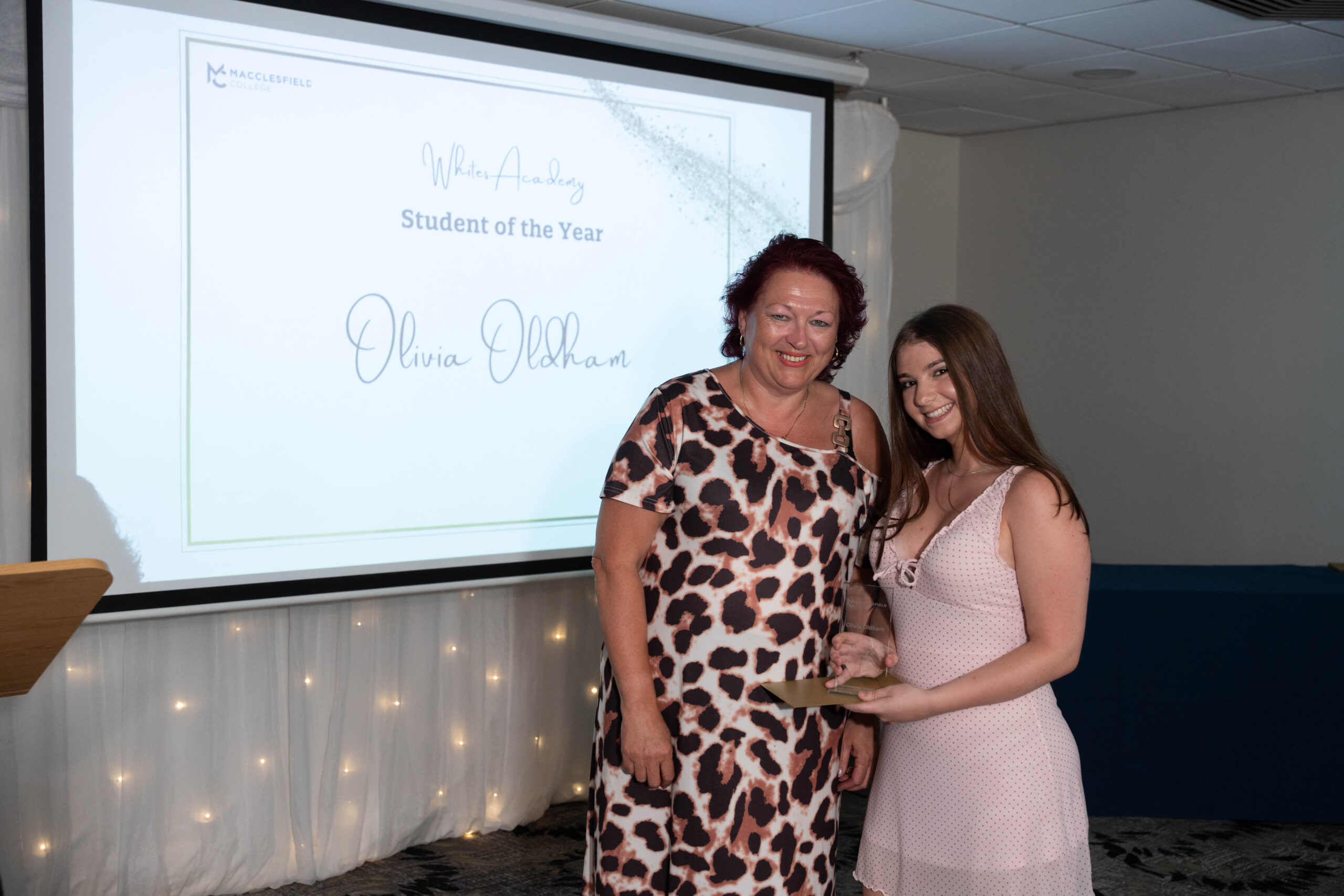 a female staff member and a female student are smiling for a photo together during a student awards event