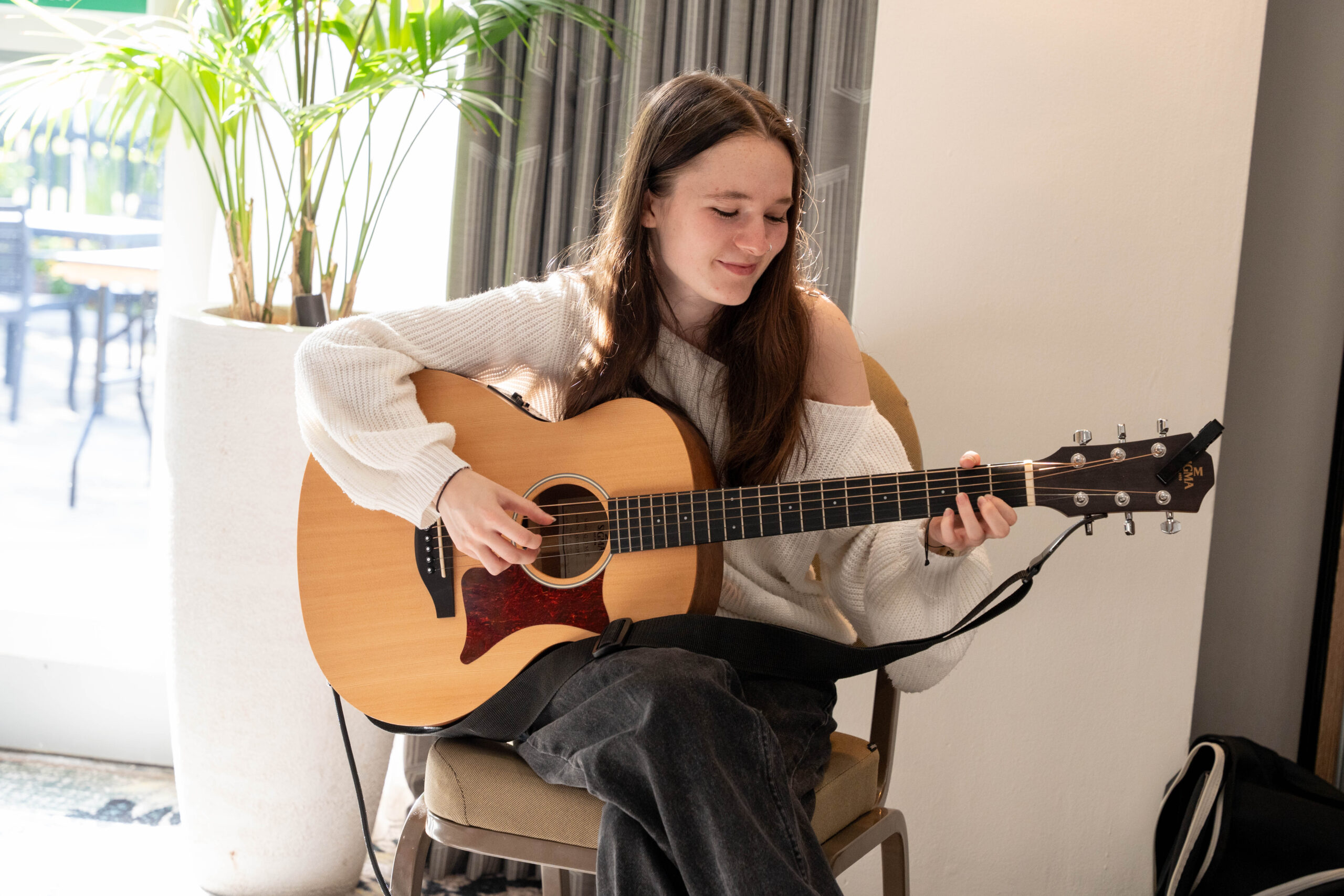 a young girl is playing the guitar