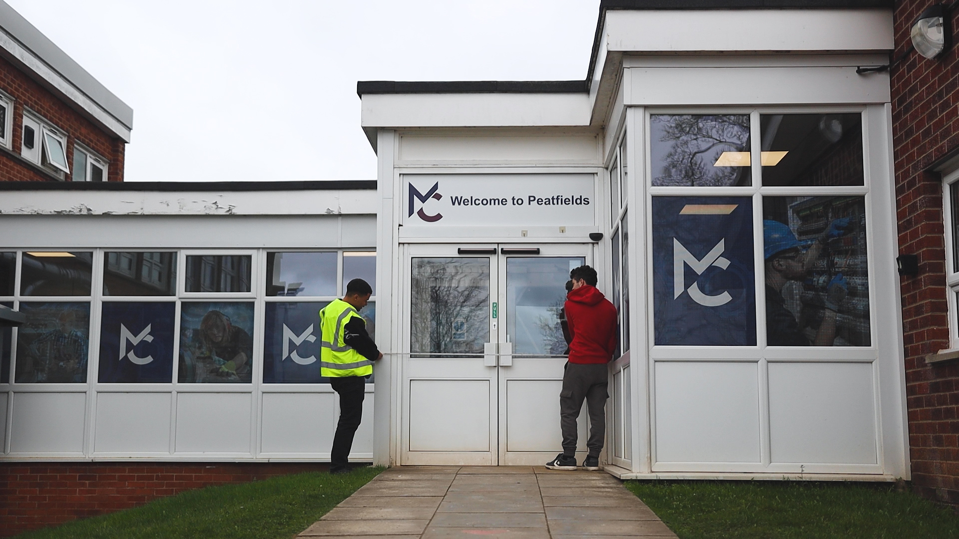 two design, surveying and planning students are measuring a building