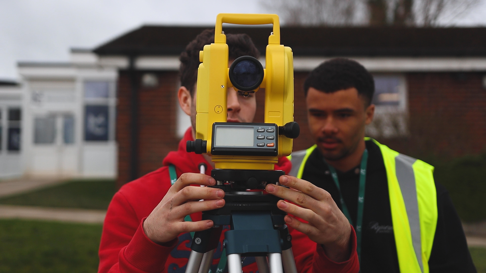 one student demonstrates how to use surveying while another watches them