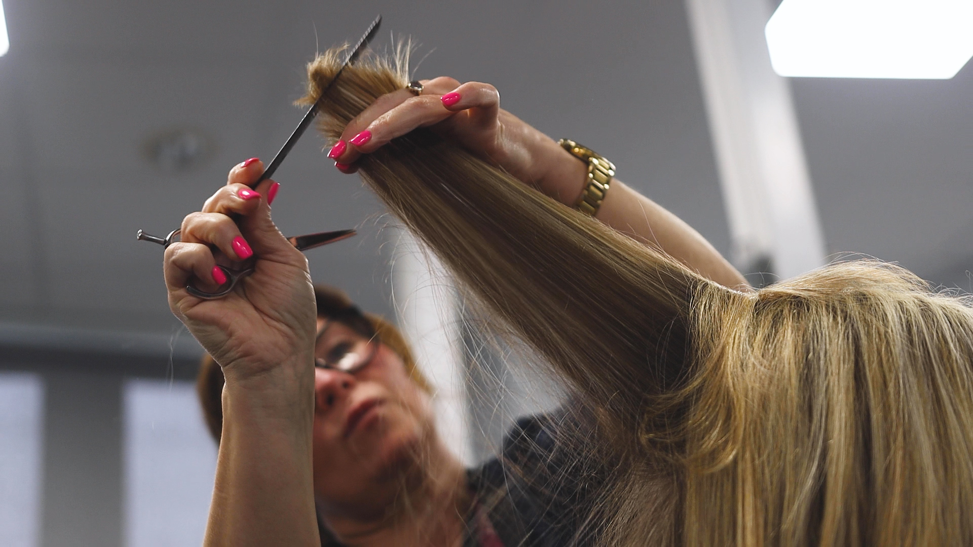 a hairdressing teacher demonstrates cutting hair