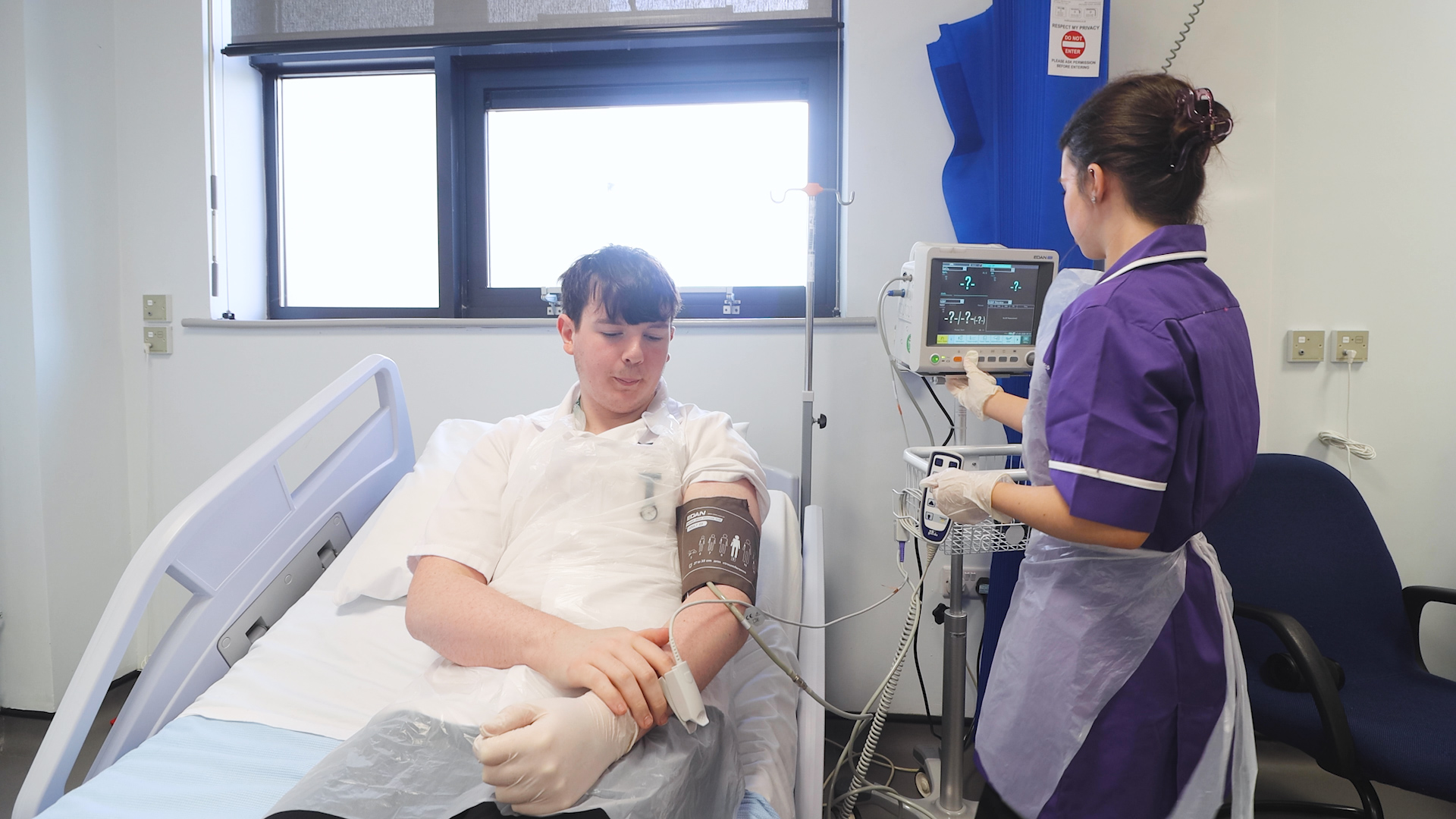 a health student practices taking another student's blood pressure