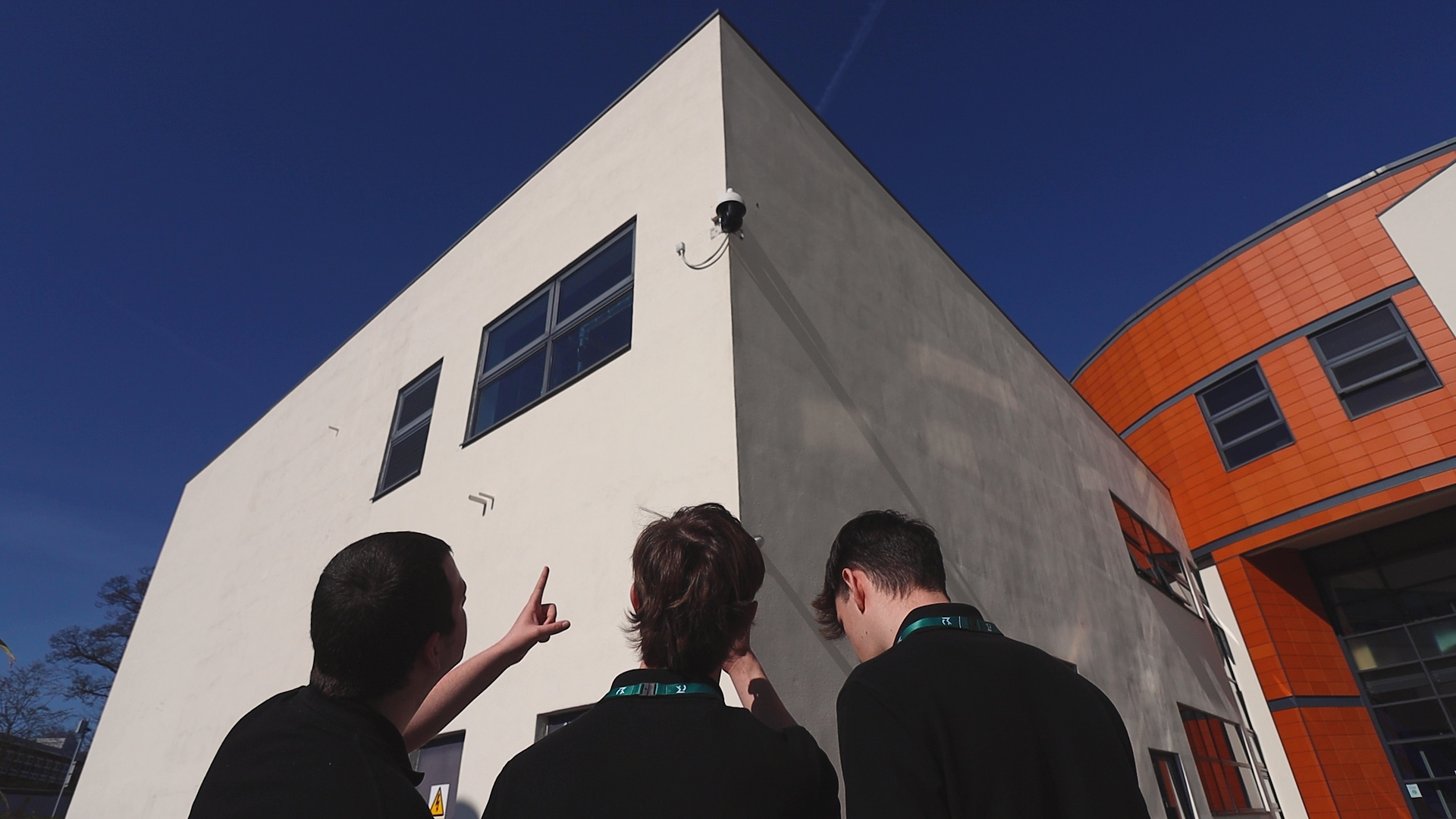Three public service students are looking at security cameras