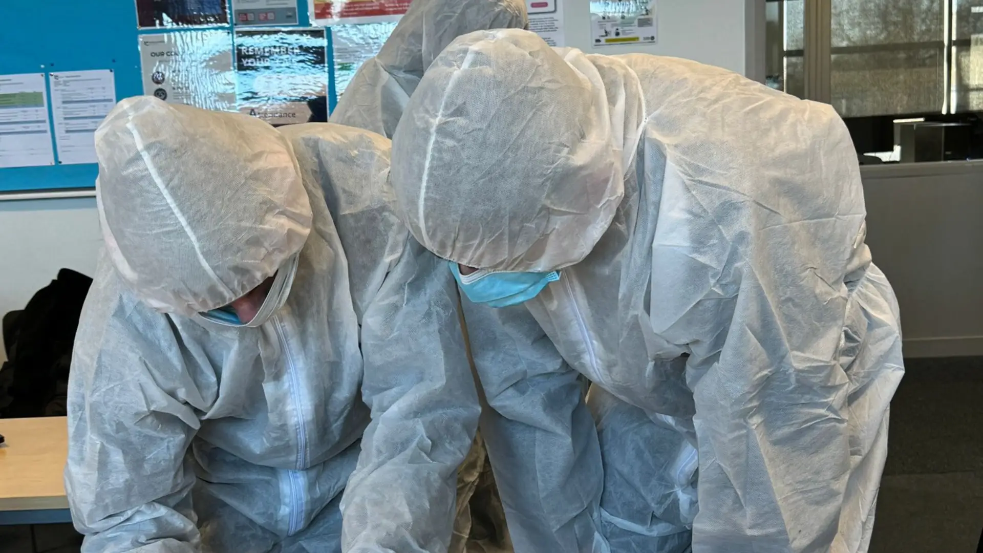 Two public service students dressed in integration scrubs are analysing evidence