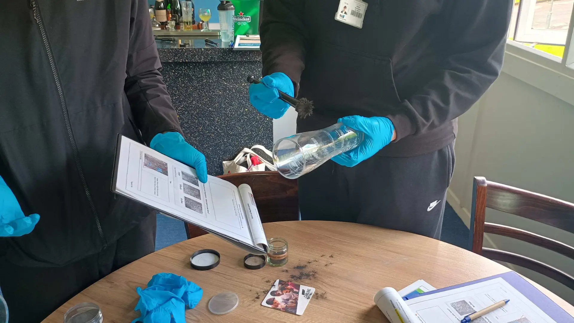 Two public service students dusting items for fingerprints