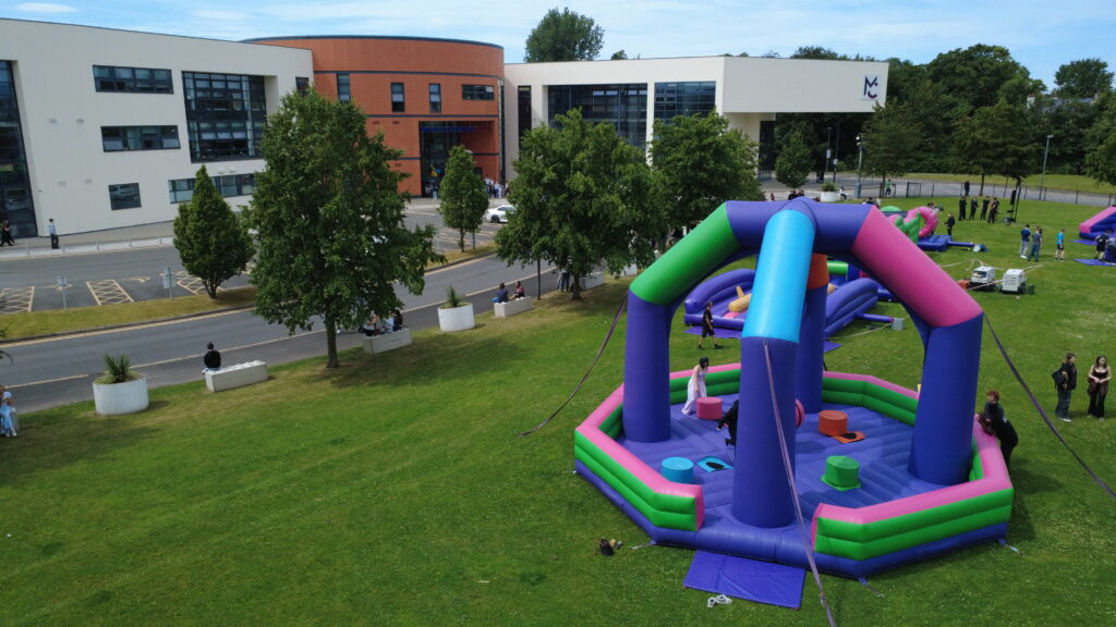 a group of students are playing on a bouncy