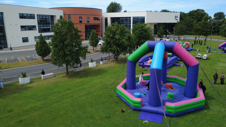a group of students are playing on a bouncy