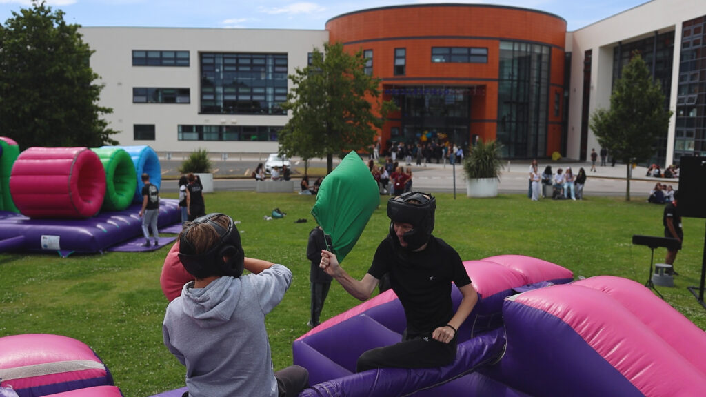 a group of students are playing on a bouncy