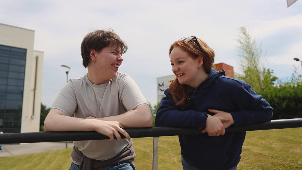 Two students are smiling while talking