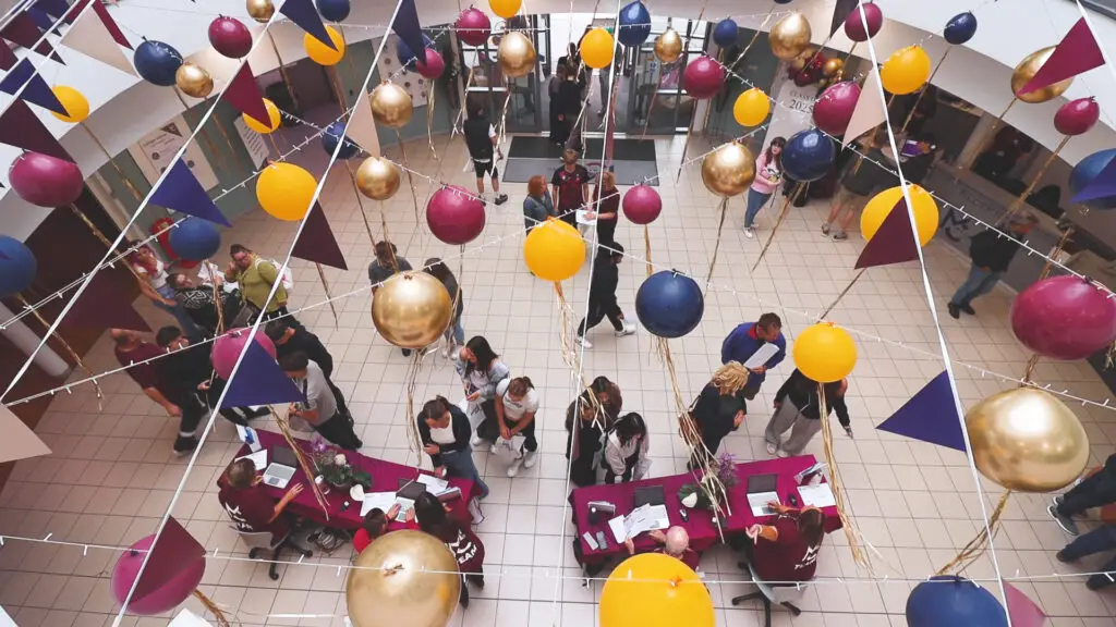 Macclesfield College during an enrolment event. People are standing inside the college talking to staff members.