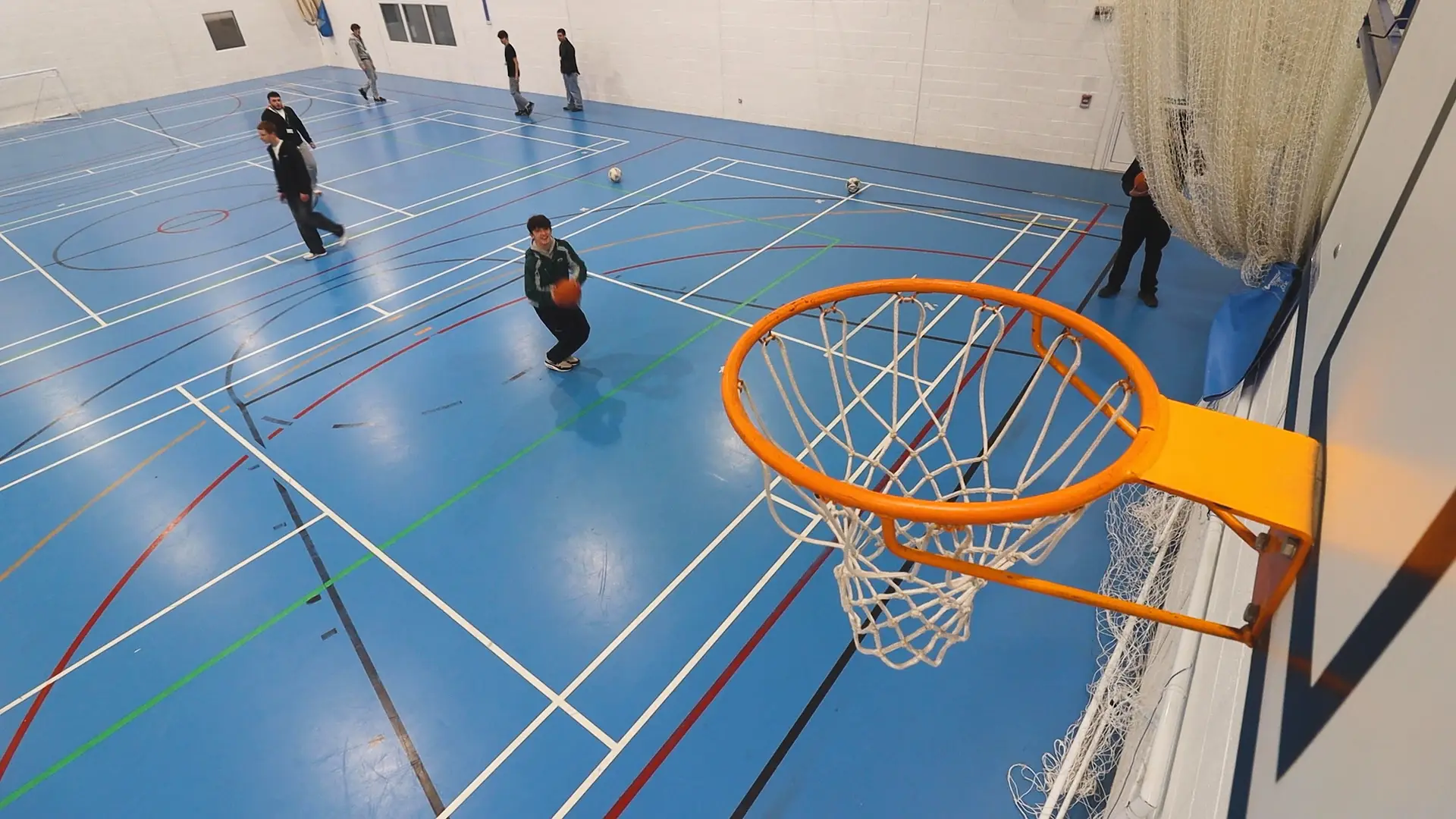 a group of students are shooting basketballs