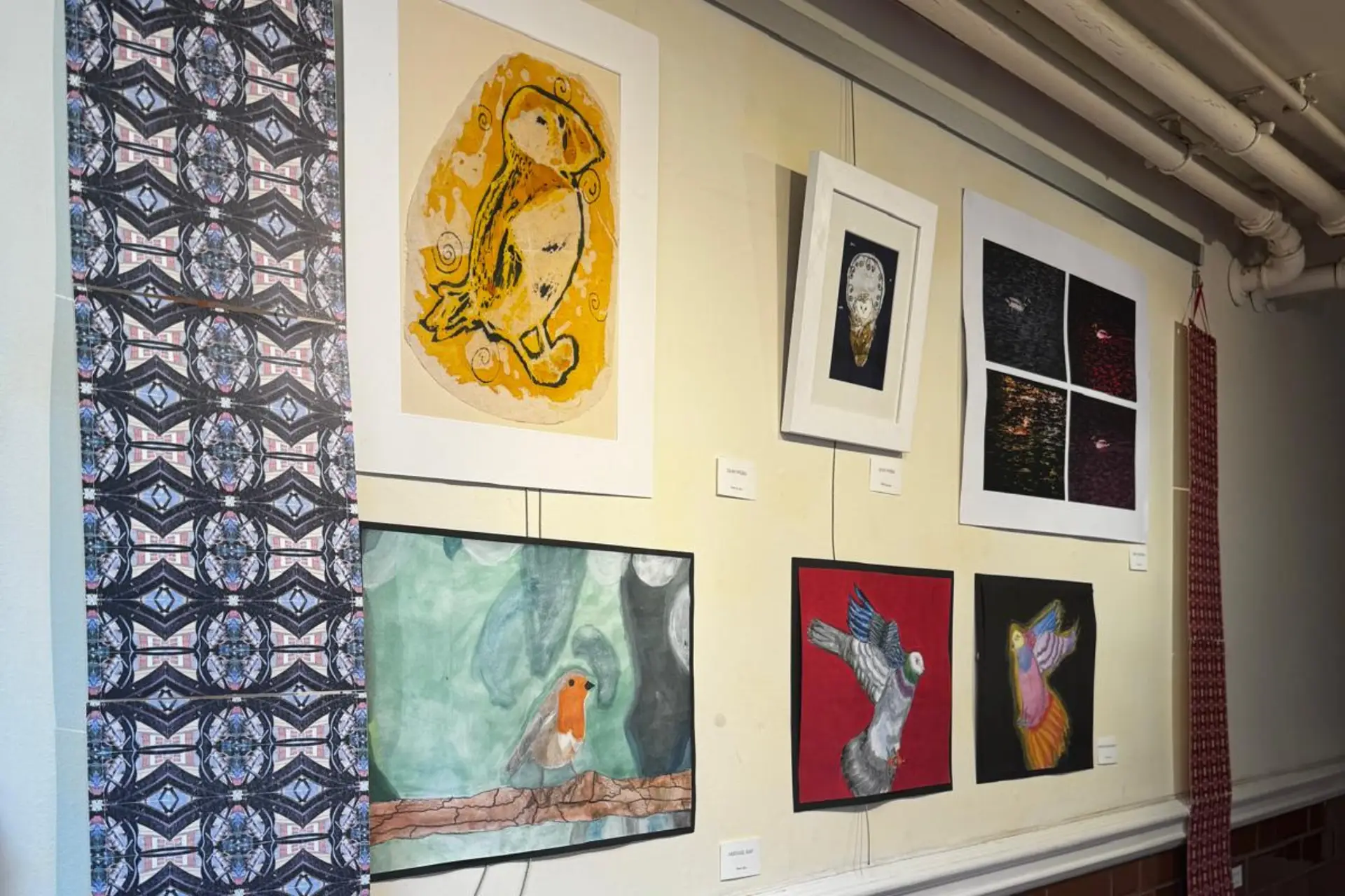 A collection of different drawings created by Macclesfield College students is hanging on a wall