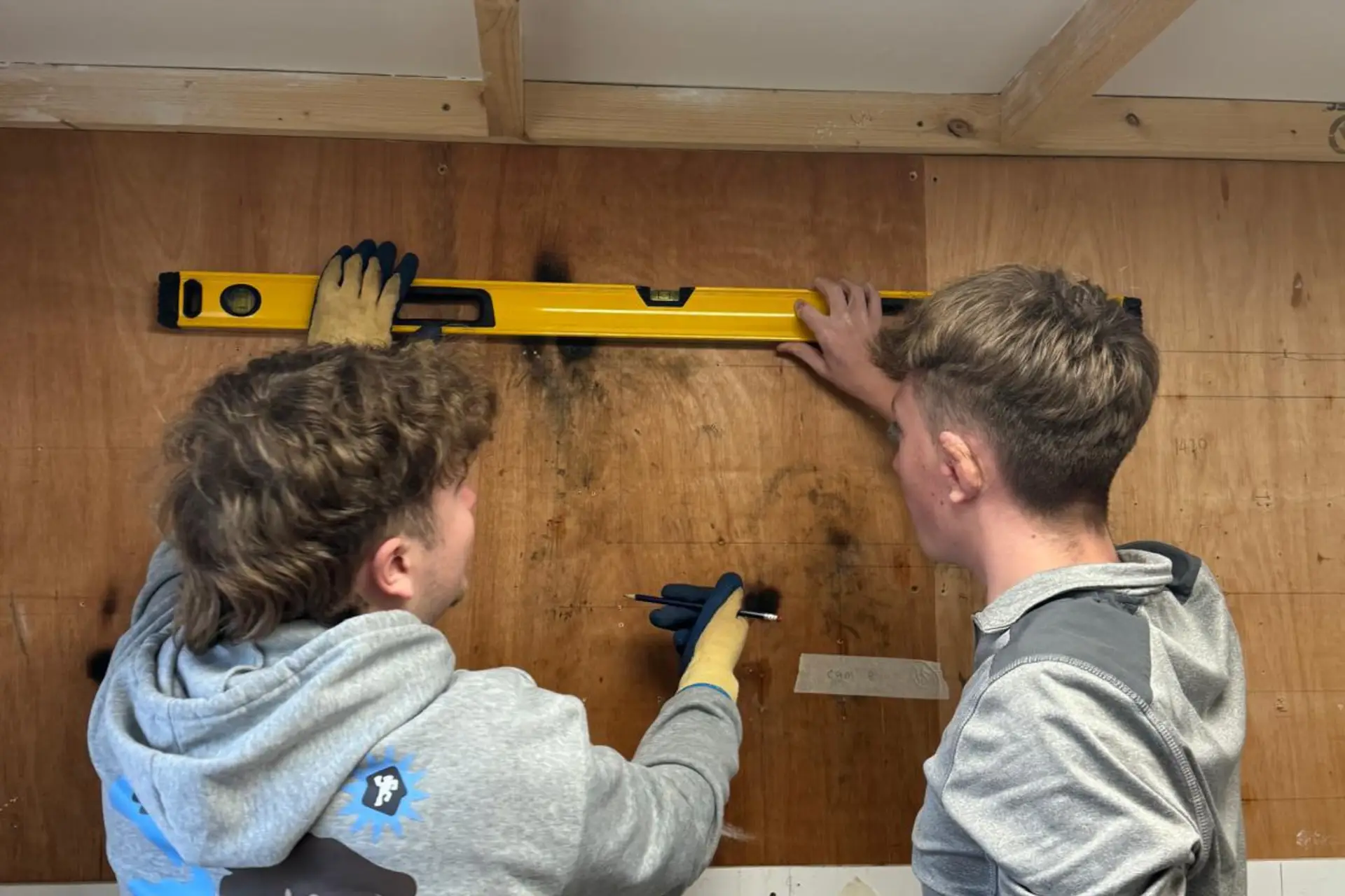 Two plumbing students are measuring pipework