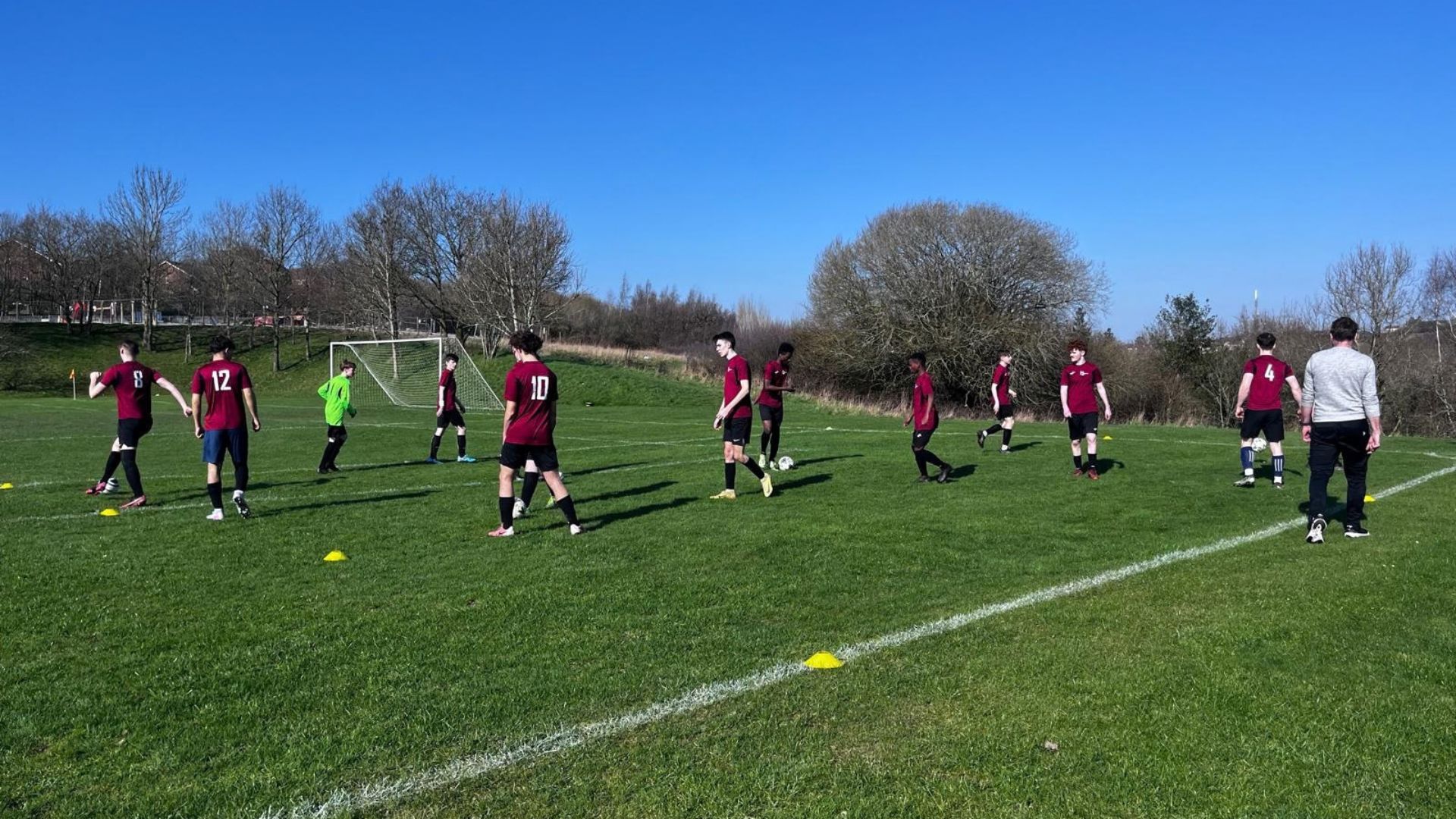 A group of students practicing football on a field